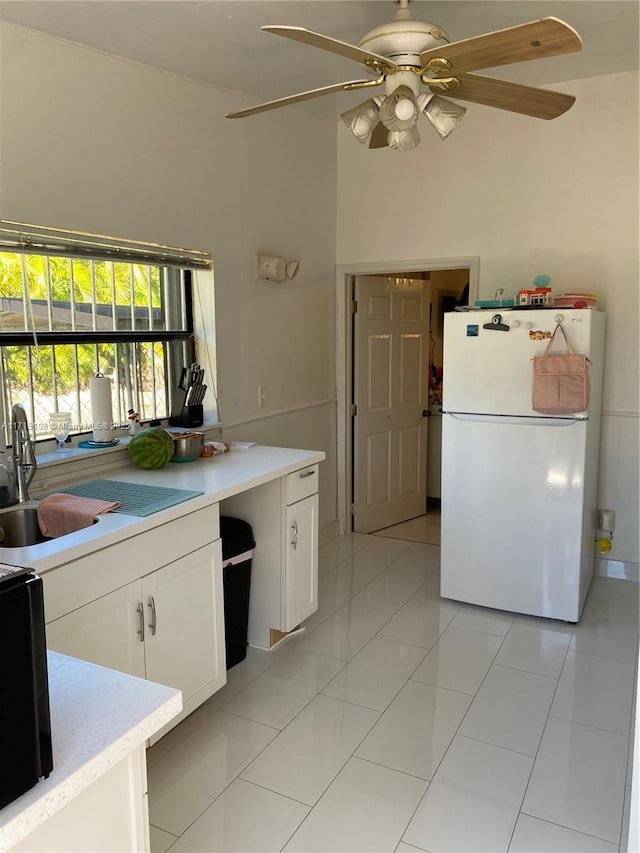 kitchen with white cabinets, ceiling fan, white refrigerator, and light tile patterned floors