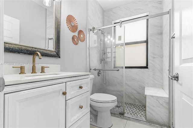 bathroom with tile patterned flooring, a shower with door, vanity, and toilet