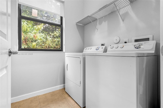 laundry room featuring light tile patterned floors and washer and clothes dryer