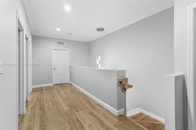 hallway featuring light wood-type flooring and ornamental molding