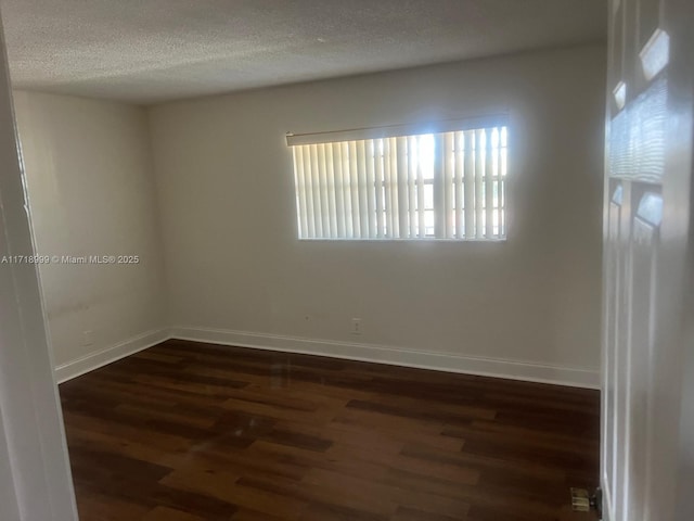 unfurnished room with dark wood-style floors, baseboards, and a textured ceiling