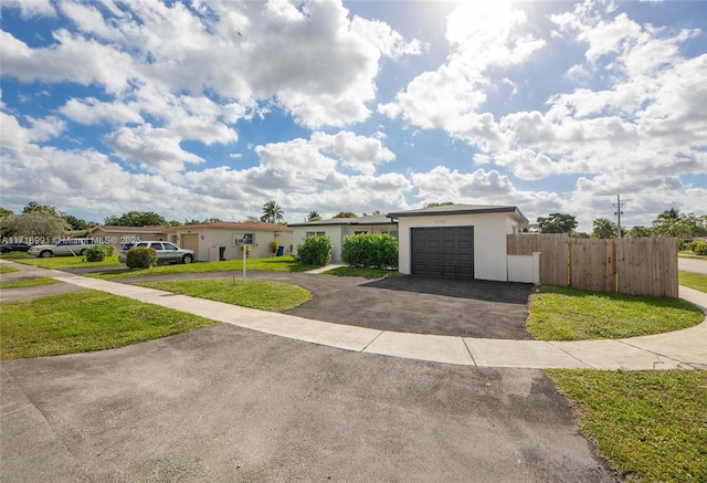 ranch-style home featuring a garage and a front lawn