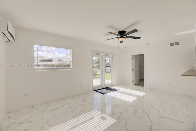 spare room featuring french doors, a wall unit AC, and ceiling fan