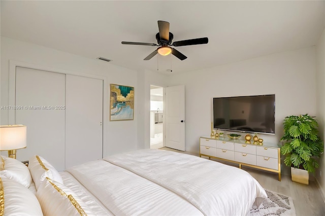 bedroom with connected bathroom, a closet, ceiling fan, and light hardwood / wood-style flooring