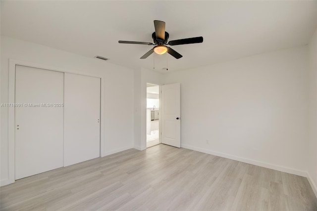 unfurnished bedroom featuring ceiling fan, light hardwood / wood-style flooring, and a closet