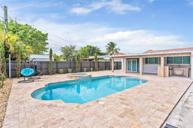 view of pool with an in ground hot tub and a patio area