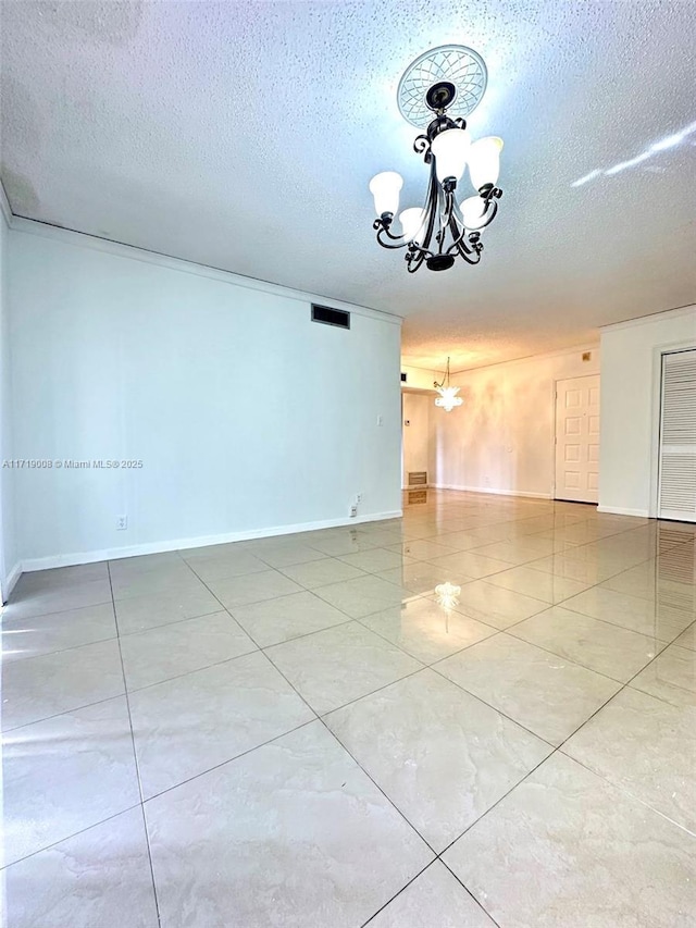 empty room with a chandelier and a textured ceiling