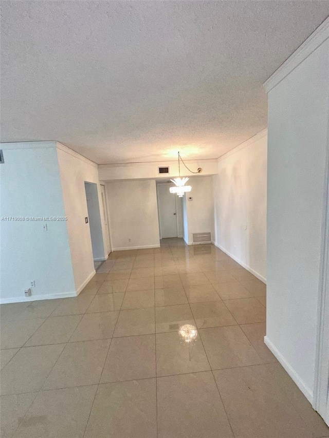 empty room featuring tile patterned flooring and crown molding