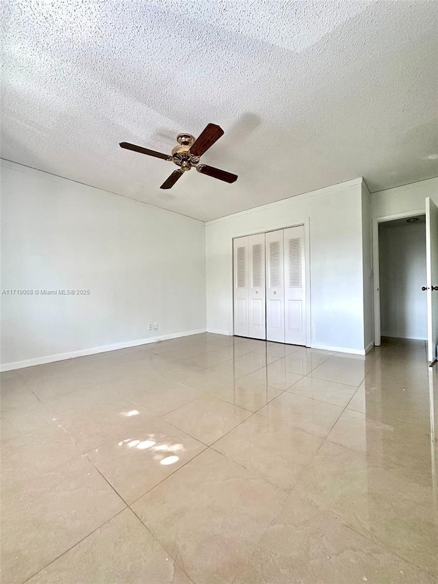 unfurnished bedroom featuring ceiling fan, a closet, and a textured ceiling