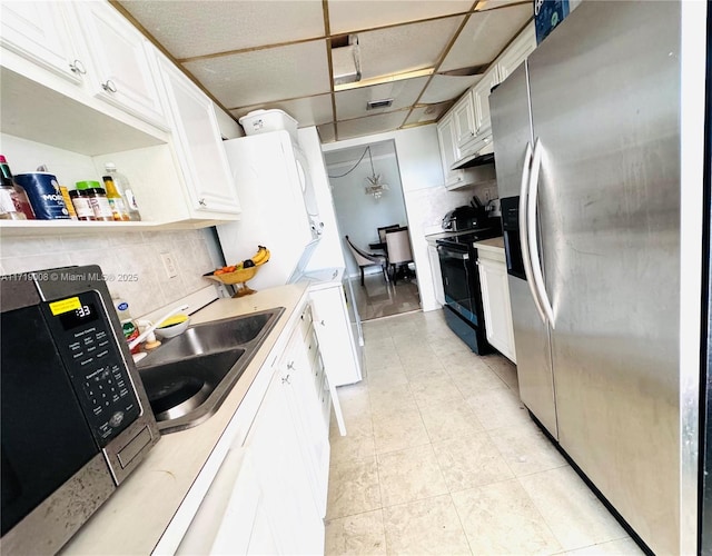 kitchen with white cabinetry, sink, electric range, tasteful backsplash, and stainless steel fridge