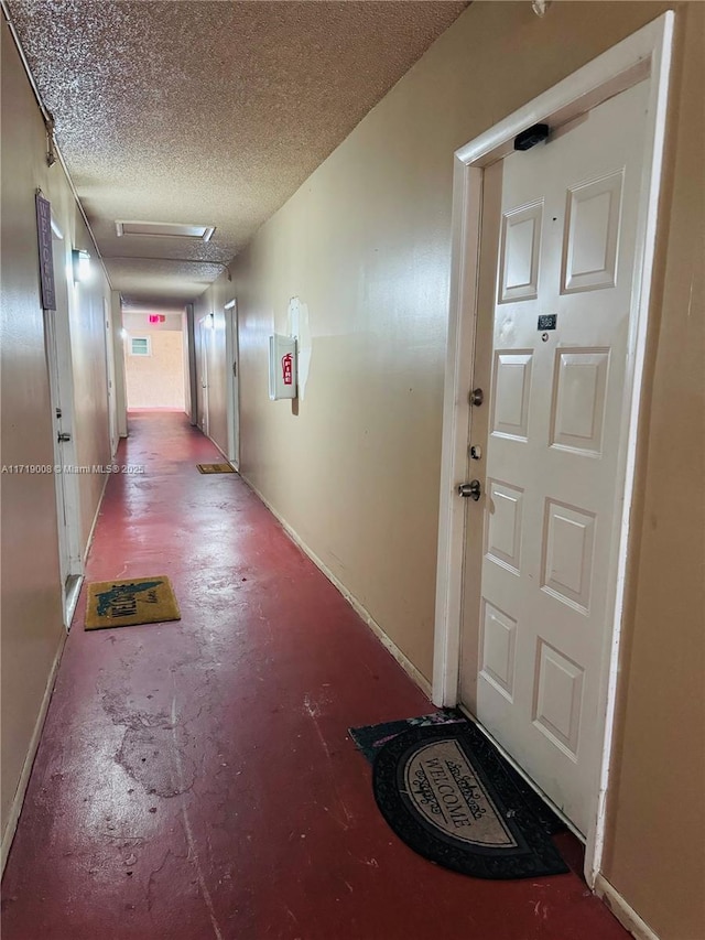 corridor featuring concrete flooring and a textured ceiling