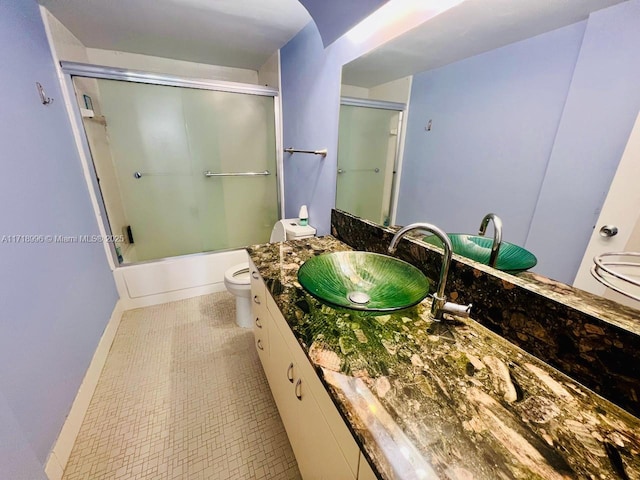 full bathroom with shower / bath combination with glass door, vanity, and toilet