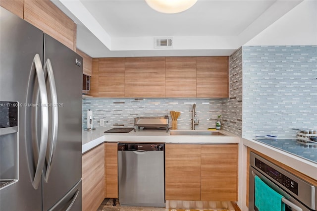 kitchen with sink, backsplash, and appliances with stainless steel finishes