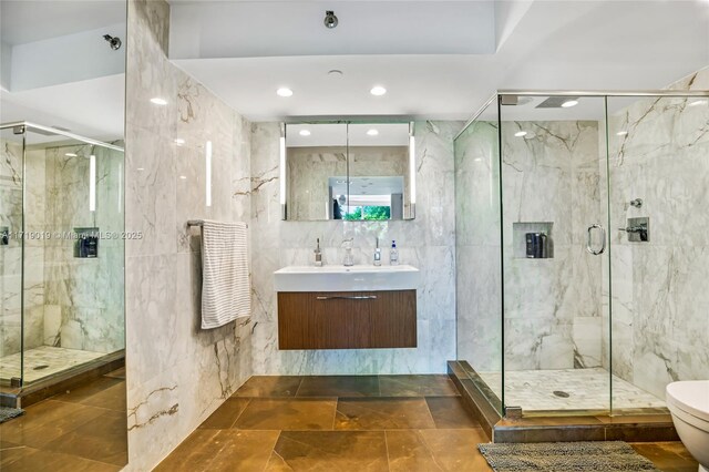 bathroom featuring an enclosed shower, vanity, toilet, and tile walls