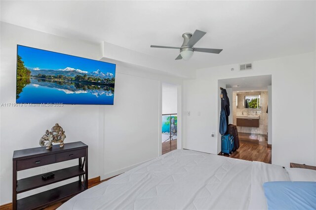 bedroom featuring hardwood / wood-style floors, ensuite bath, and ceiling fan