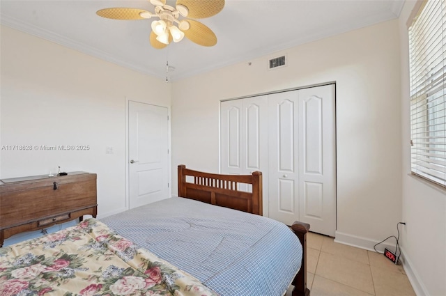 tiled bedroom with a closet, ceiling fan, and crown molding