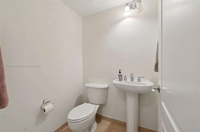 bathroom featuring sink, toilet, and tile patterned flooring