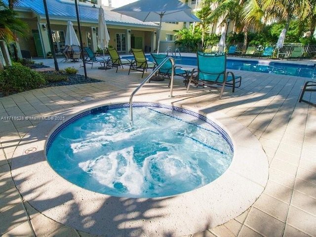 view of pool with a patio and a hot tub