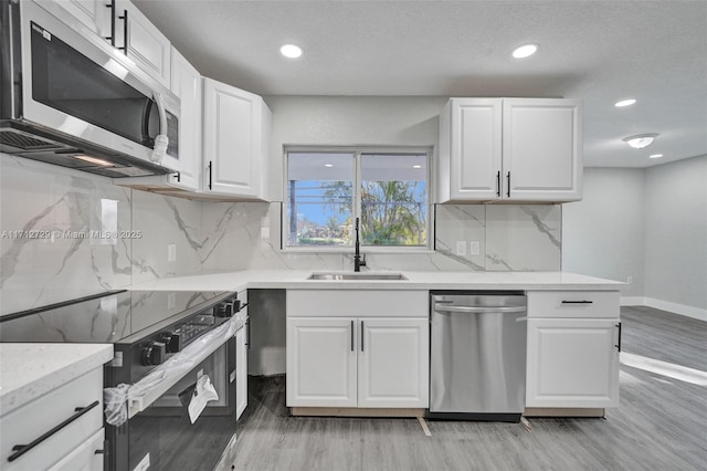 kitchen with white cabinets, stainless steel appliances, and sink