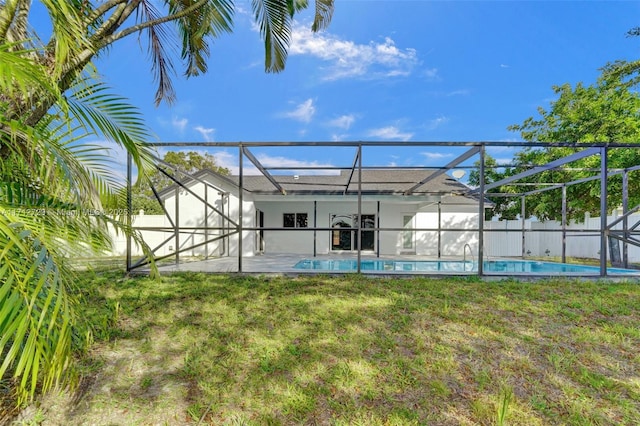 back of property featuring a lawn, a lanai, and a patio