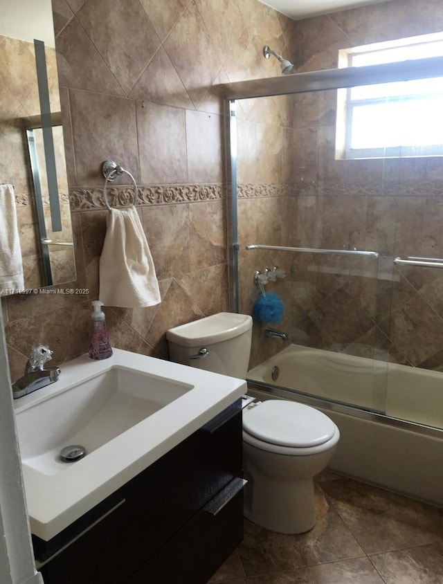 full bathroom featuring vanity, bath / shower combo with glass door, and toilet