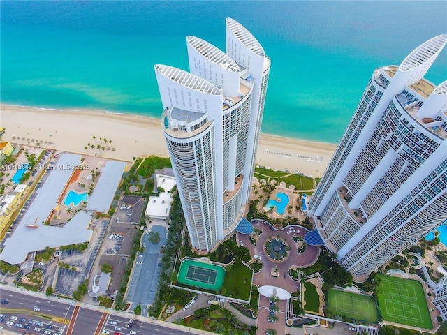 birds eye view of property with a water view and a beach view