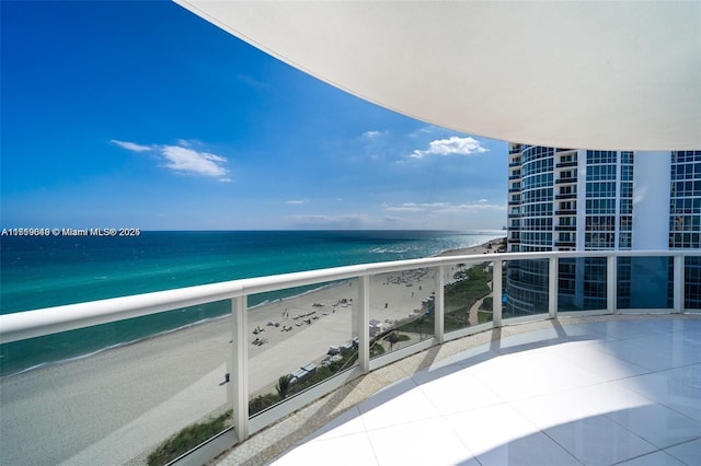 balcony with a beach view and a water view