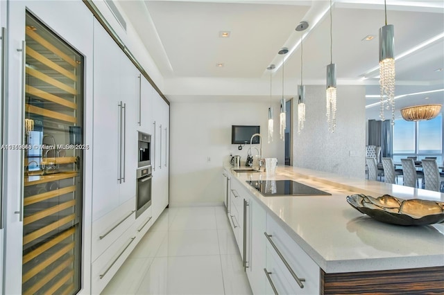 kitchen with white cabinetry, wine cooler, oven, decorative light fixtures, and black electric cooktop