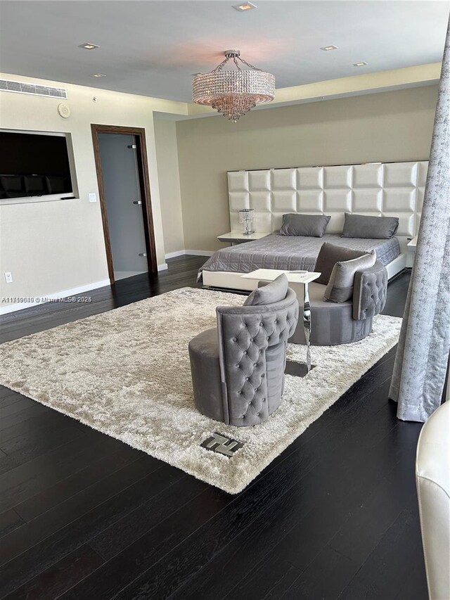 bedroom with dark hardwood / wood-style flooring and a notable chandelier