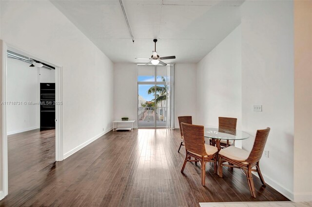 dining room featuring dark hardwood / wood-style flooring, expansive windows, and ceiling fan