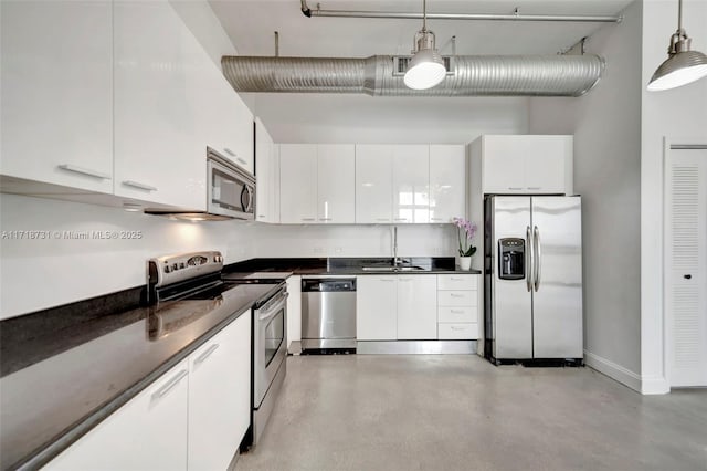 kitchen with sink, decorative light fixtures, white cabinets, and appliances with stainless steel finishes