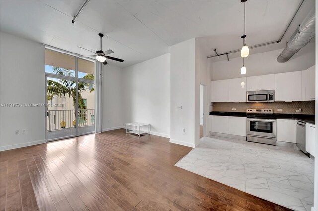 living room featuring expansive windows, ceiling fan, and dark hardwood / wood-style floors