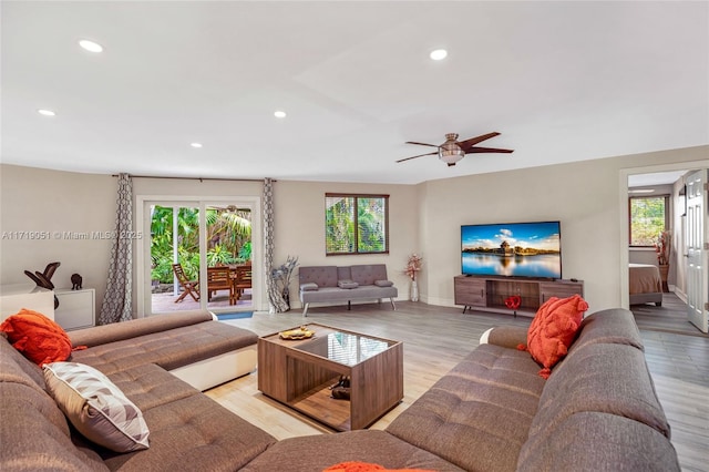 living room featuring ceiling fan and light hardwood / wood-style flooring