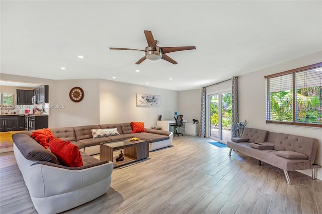 living room featuring light hardwood / wood-style flooring and ceiling fan