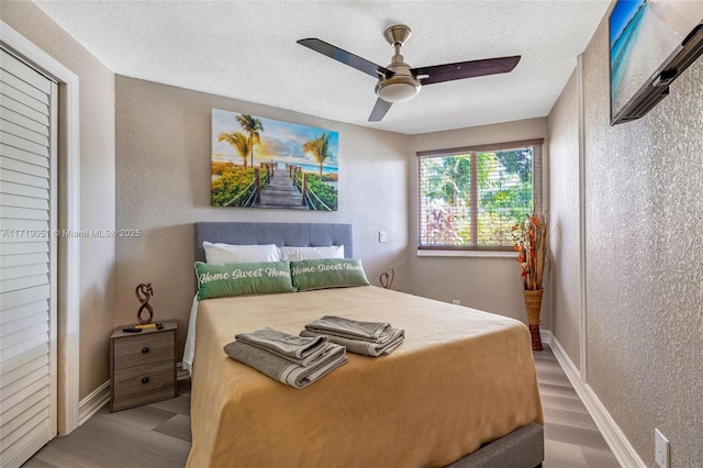 bedroom with ceiling fan, light hardwood / wood-style floors, and a textured ceiling