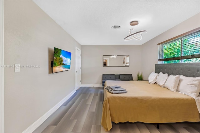 bedroom with a textured ceiling and hardwood / wood-style flooring