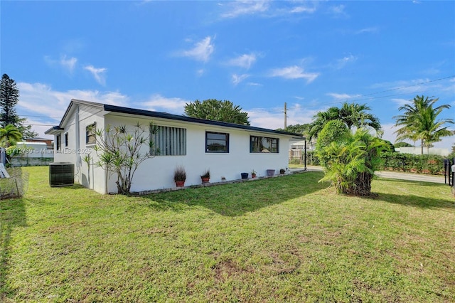 exterior space with central AC and a front lawn