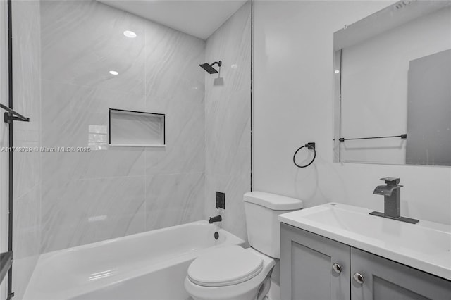 full bathroom with toilet, vanity, and tiled shower / bath