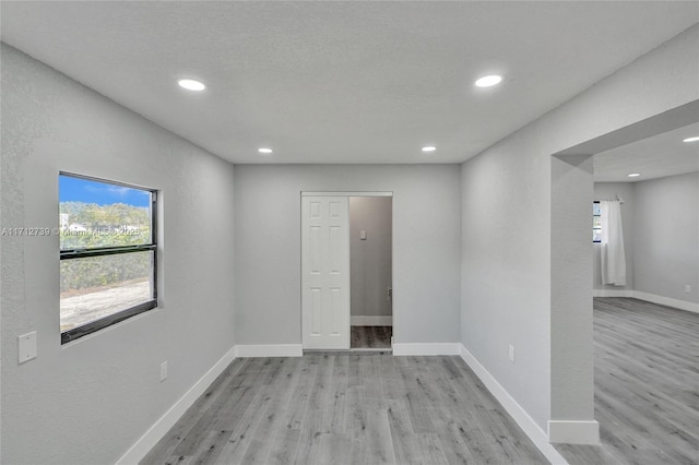 spare room with light hardwood / wood-style flooring and plenty of natural light