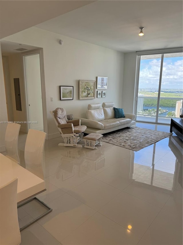 tiled living room featuring expansive windows and electric panel