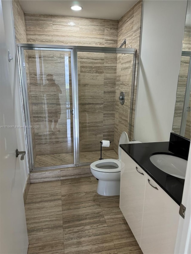 bathroom with walk in shower, tile patterned flooring, vanity, and toilet