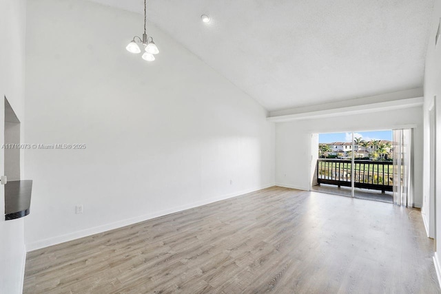 unfurnished room featuring light hardwood / wood-style flooring, high vaulted ceiling, and an inviting chandelier