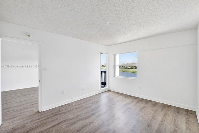 spare room featuring hardwood / wood-style floors and a textured ceiling