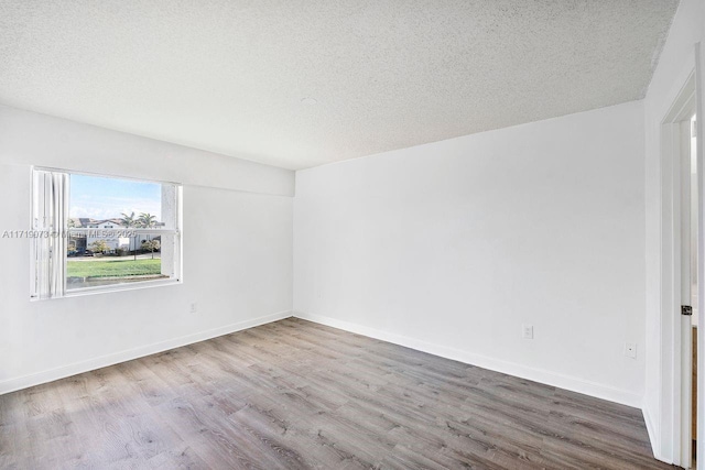 unfurnished room featuring hardwood / wood-style floors and a textured ceiling