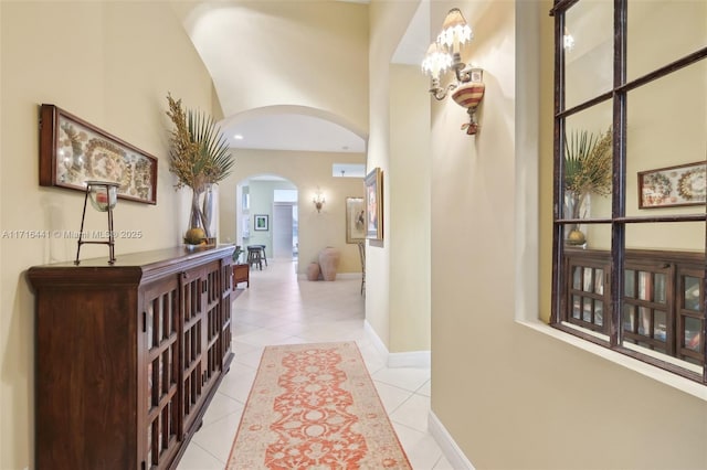 hall with light tile patterned floors and vaulted ceiling