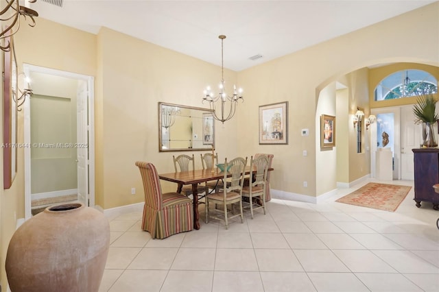 tiled dining room featuring an inviting chandelier