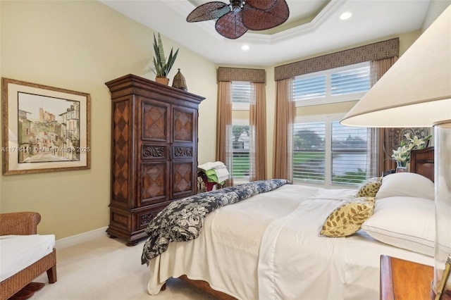 bedroom with light carpet, a tray ceiling, ceiling fan, and ornamental molding