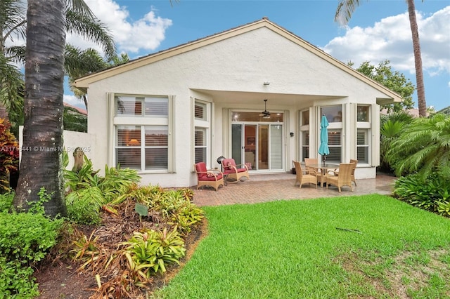 back of house featuring a patio area, ceiling fan, and a yard