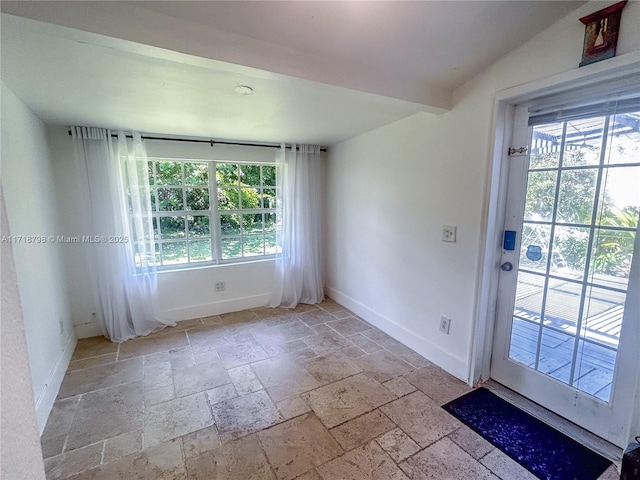 spare room with lofted ceiling and a healthy amount of sunlight