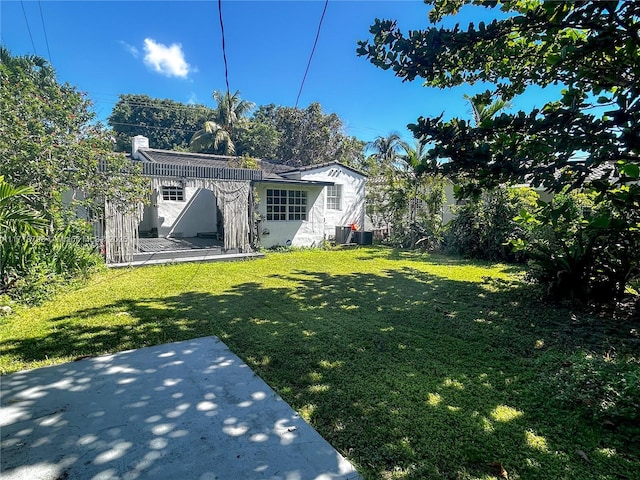 view of yard with central AC and a patio area